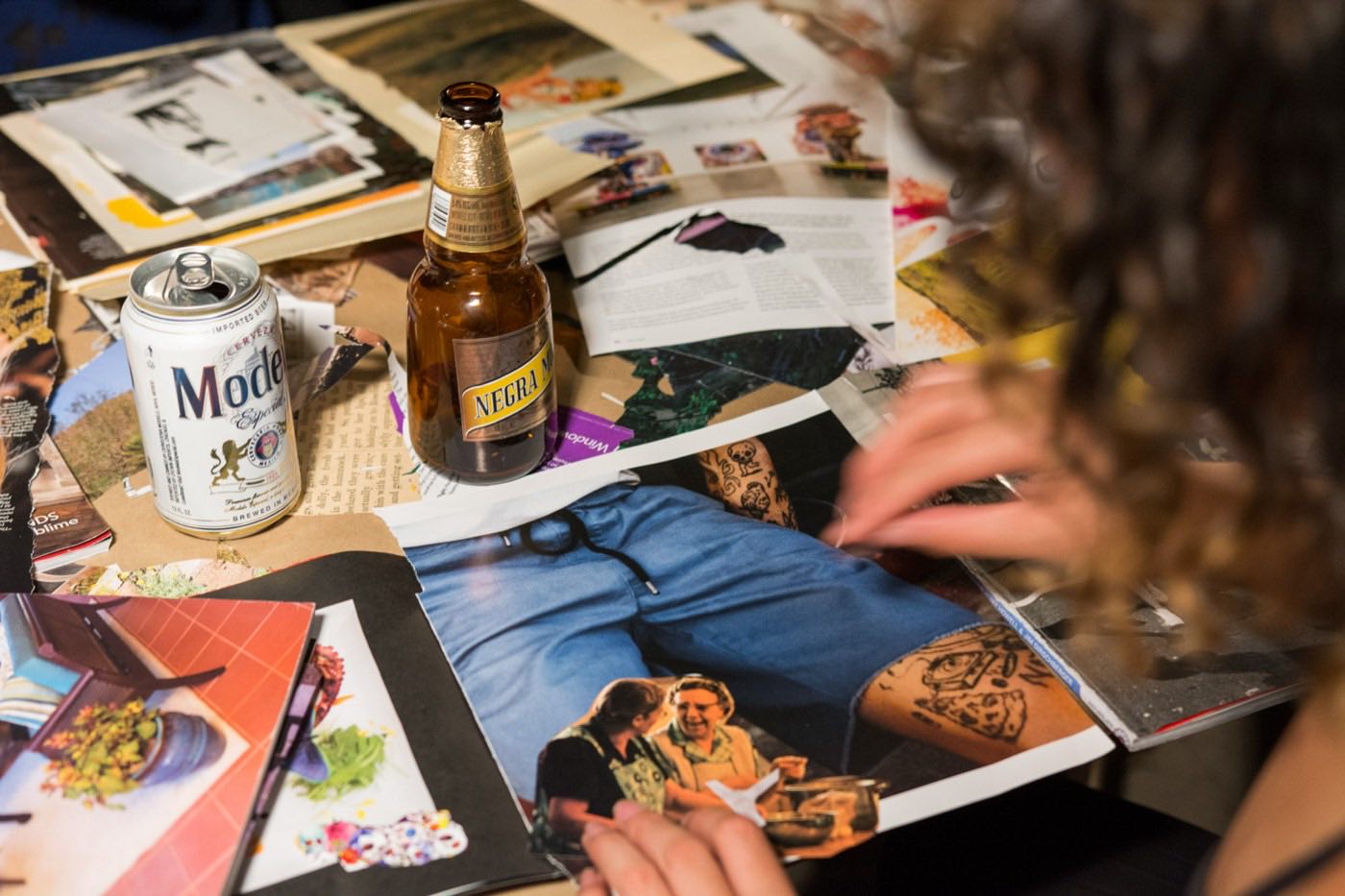 Hands cutting shapes from magazine pages amid scattered clippings.